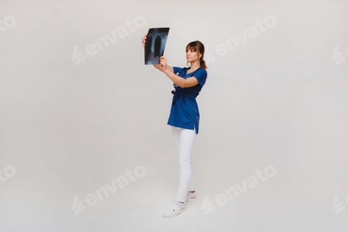 Preview: Female Brunette Doctor Looking at Tomography X-ray Film