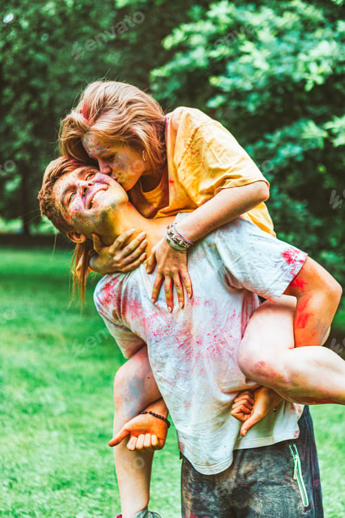 Preview: young pretty couple having fun at holi fest