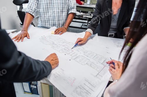 Preview: Teamwork in action analyzing architectural blueprints at a busy office.