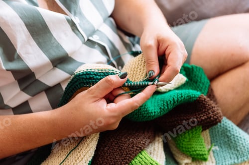 Preview: Person Knitting a Colorful Wool Blanket at Home