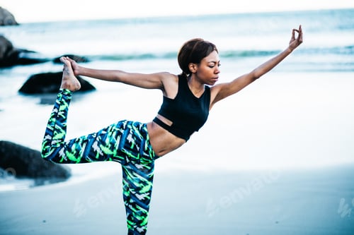 Preview: Young female women doing Yoga on the beach in the morning