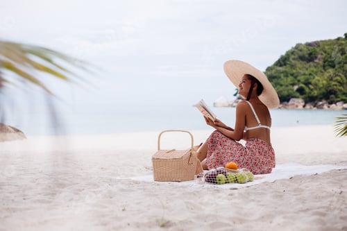 Preview: woman sit on beach carpet blanket having picnic with basket of fruits