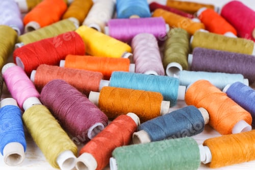Preview: Multicolor sewing threads on white wooden background
