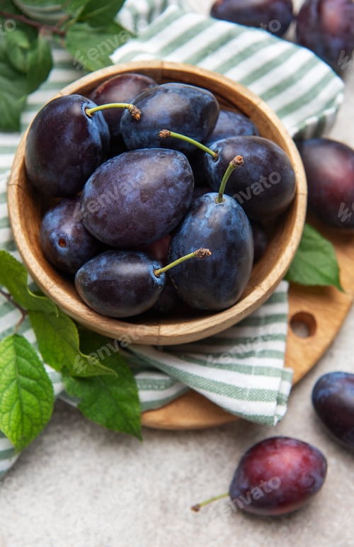 Preview: Fresh ripe plums filling a wooden bowl