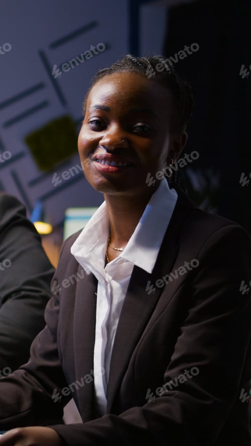 Preview: Portrait of focused african american woman writing investment strategy on notebook working overtime
