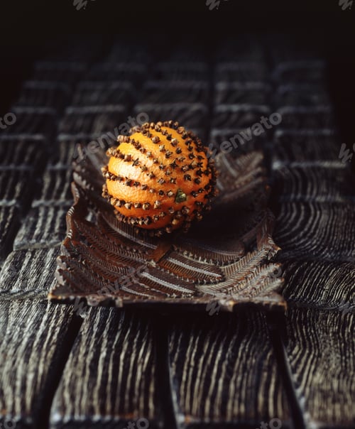 Preview: Orange with cloves stuck in, on vintage wooden plate