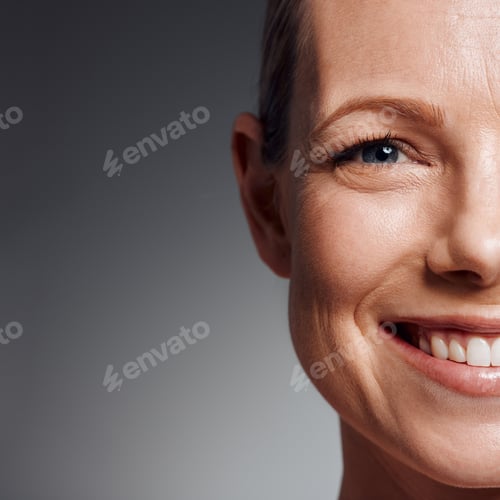 Preview: Beautiful mature woman posing in studio against a grey background