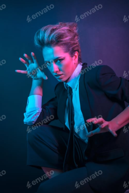 Preview: A sexy young blonde hair female in a black suit posing in studio