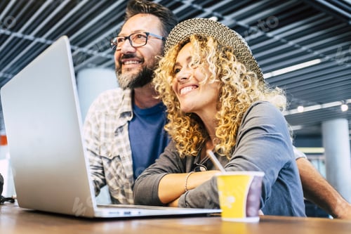 Preview: Happy and cheerful people couple with computer