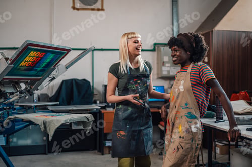 Preview: Smiling interracial printing industry workers talking at facility.