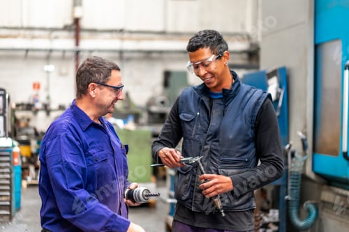 Preview: Instructor teaching and speaking the trade to a metal industrial factory worker