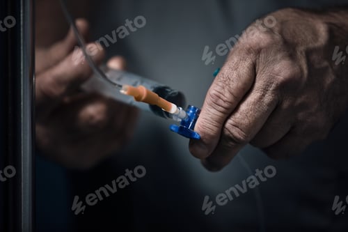 Preview: Hands of the doctor make an injection in a dropper. Dramatic scene, close-up. Saving lives, deadly