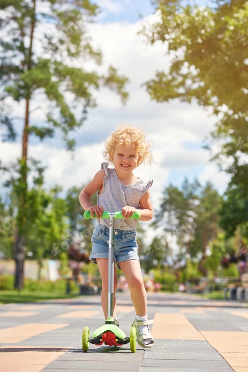 Preview: Little girl riding a scooter at the park