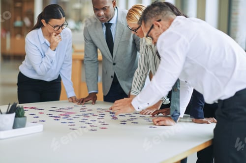 Preview: Diverse businesspeople trying to solve a puzzle in an office