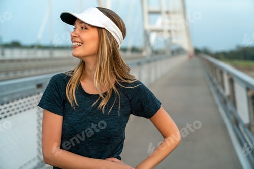 Preview: YYoung smiling satisfied fit woman resting after an active fitness training outdoors in city