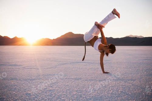 Visualização: Mulher praticando capoeira em Bonneville Salt Flats ao pôr do sol, Utah, EUA
