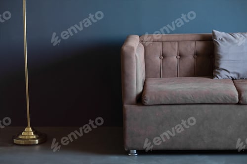 Preview: brown sofa against a dark blue wall, copy space. dark interior.