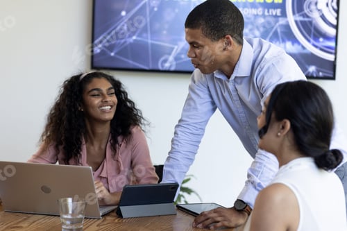 Preview: Discussing project with laptops, African American woman and colleagues in modern office