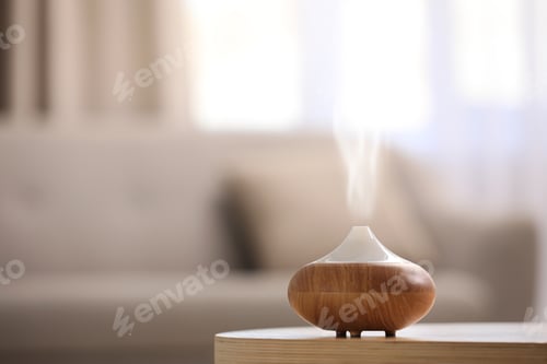 Preview: Modern essential oil diffuser on table indoors. Space for text