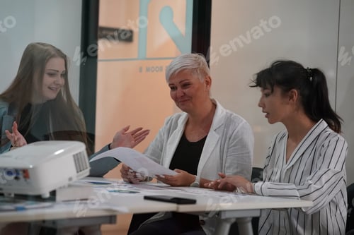 Preview: Three young business teamwork sitting together and discussing over business report