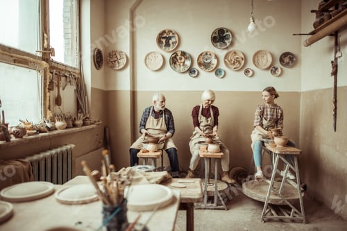 Preview: Grandmother and grandfather with granddaughter making pottery at workshop