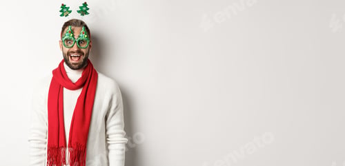 Preview: Christmas, New Year and celebration concept. Handsome bearded man looking surprised, wearing party