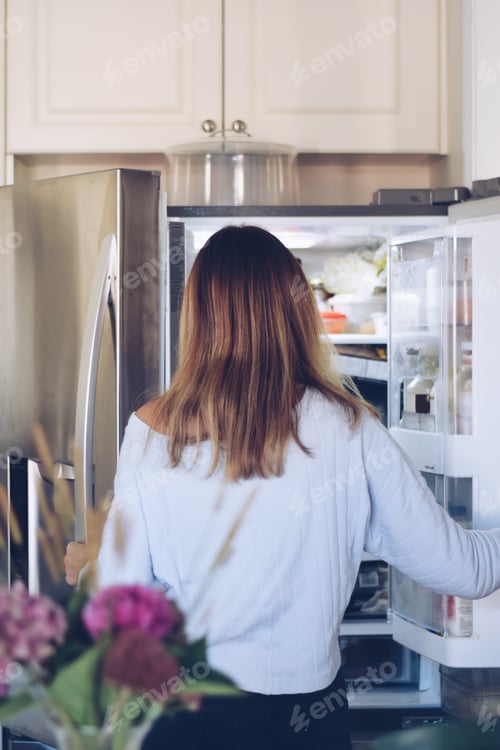 Preview: Young teenage girl is taking food from refrigerator