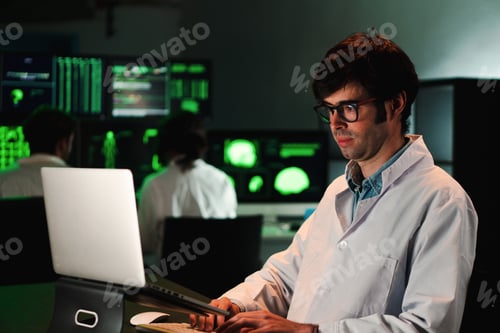 Preview: Serious biology scientific man working concentrated on pharmacy medical analysis with a laptop