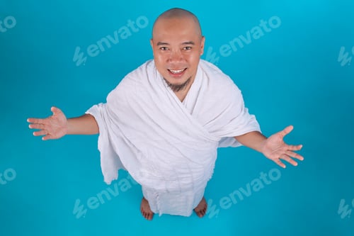 Preview: High Angle View of Smiling Muslim Pilgrim in White Ihram Clothes Opening Arms Wide
