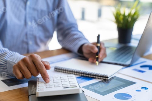 Preview: business office worker sitting at a desk using a calculator to calculate Financial data analysis and