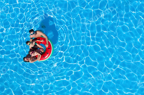 Preview: Happy family with inflatable ring in swimming pool, top view. Space for text