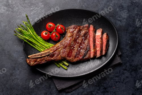 Preview: Medium rare grilled Tomahawk beef steak with asparagus