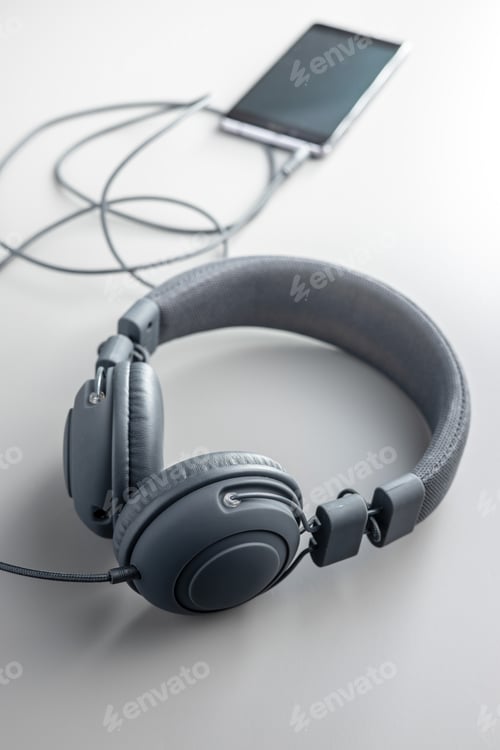 Preview: Wired stereo headphones connected to the smartphone on a gray background.
