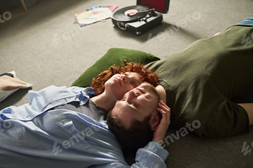 Preview: Young Couple Relaxing Together on Floor Listening to Vinyl Records