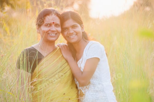 Preview: Portrait of happy mother and daughter in meadow at sunset. Smart Blurred photo