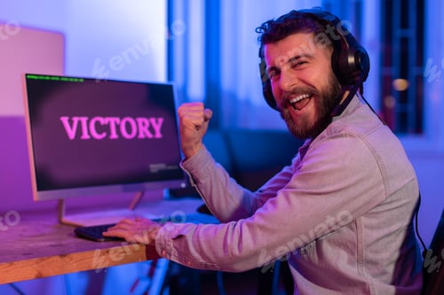 Preview: Millennial guy celebrates gaming victory, clenching fist