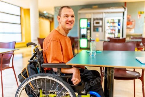 Preview: Man with disability sitting drinking water in the university cafeteria