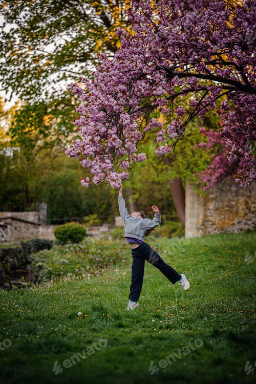 Preview: Girl Reaching for Cherry Blossoms in Blooming Spring Garden
