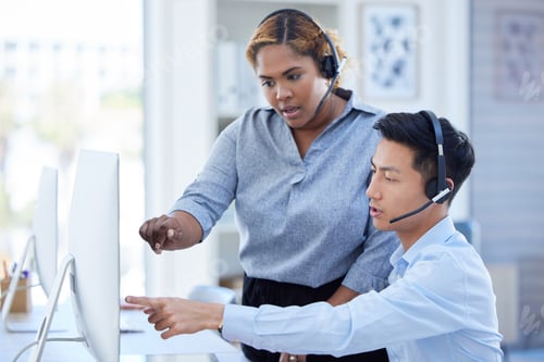 Preview: Young african american call centre telemarketing agent training new asian assistant on a computer i