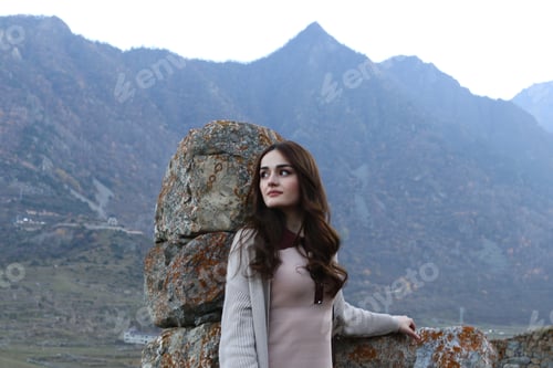 Preview: Thoughtful Woman Poses Near Stone Wall Outdoors