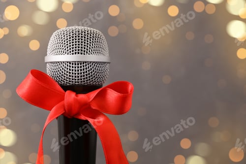Preview: Microphone with red bow on grey background, space for text. Christmas music