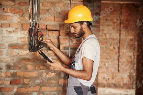 Preview: Wireless device in hands, digital tablet. Handsome Indian man is on the construction site