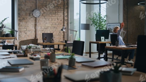 Preview: Office worker riding chair between tables in empty office. Lady having fun alone