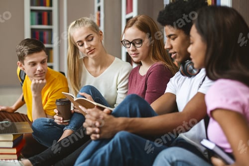 Preview: Five classmates reading lecture notes, sitting on library floor