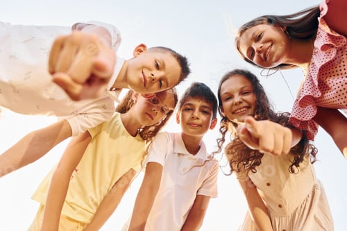 Preview: View from below of group of kids that looking down and having fun