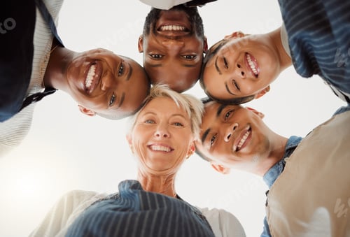 Preview: Low portrait of a group of five cheerful diverse clothing designers standing together in an office