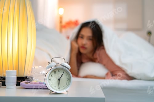 Preview: Asian young woman on the bed in the bedroom trying to wake up and prepare for work