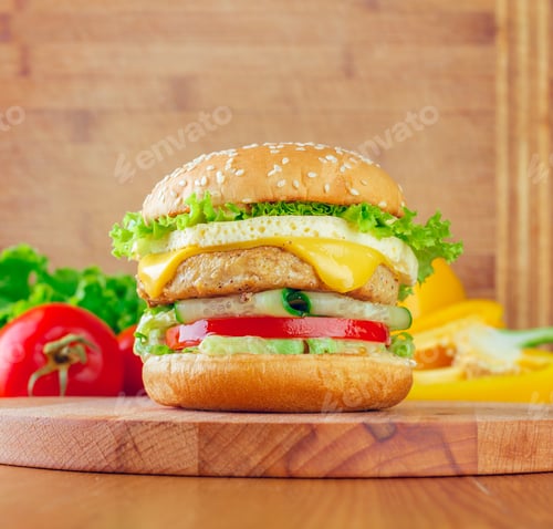 Preview: Delicious burger with cheese, lettuce, tomato, and cucumber on a wooden cutting board in a cozy