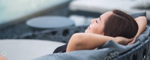 Preview: Woman Relaxing in Chair With Hands Behind Head