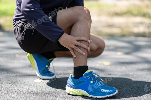Preview: Young fitness man holding his sports leg injury, muscle painful during training.